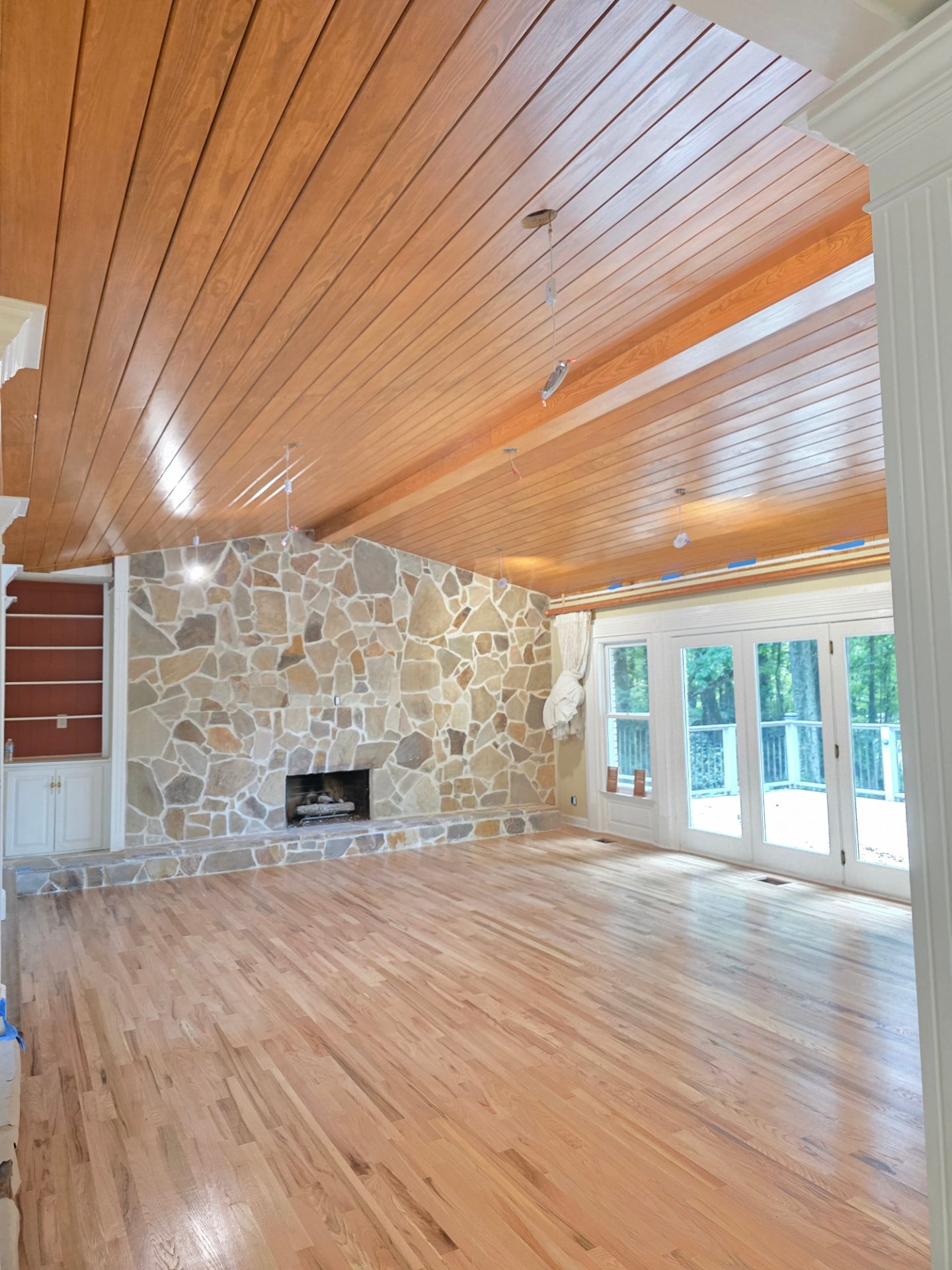 Stained tongue-and-groove ceiling with a refinished hardwood floor.